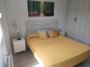 Un dormitorio con una cama amarilla con un cuadro en la pared. en Spacious with free parking in Old Town-Casco Viejo, en Bilbao