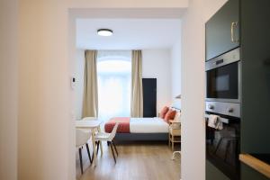 a hotel room with a bed and a table and chairs at Apartment Berthelot 5 in Brussels