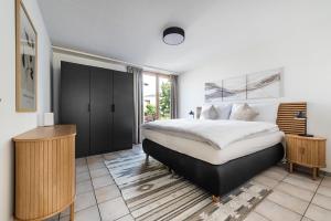 a bedroom with a king sized bed and a desk at Haus mit Garten, Sauna und Parkplatz in Kreuzlingen