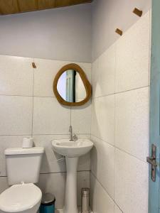a bathroom with a toilet and a sink and a mirror at Suite Sol - Quarto e Banheiro com Ar Condicionado in Luis Correia +10 photos