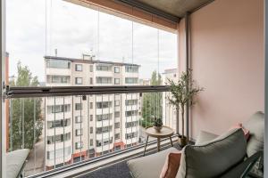 Zimmer mit einem großen Fenster und Blick auf ein Gebäude in der Unterkunft Loft Stadium City in Tampere