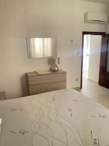 a bedroom with a bed and a dresser and a mirror at La Dolce Sosta in Luras