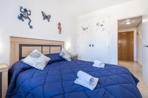 a bedroom with a large blue bed with pillows at Gemelos 22 Resort Apartment 2-15-B Levante Beach in Benidorm +45 photos