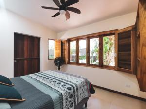 a bedroom with a bed and a ceiling fan at Casa Jobo en Puerto Viejo in Hone Creek
