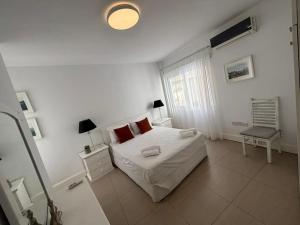 Un dormitorio blanco con una cama y una ventana. en Modern 2BR Apartment 70m from Finikoudes beach, en Lárnaca