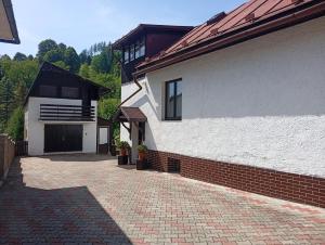 a house with a brick driveway next to a building at Rekreačný dom E&Z in Brezno