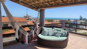 eine Hollywoodschaukel mit Kissen auf dem Balkon in der Unterkunft Vila Nordestina in Caucaia