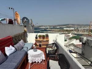 a patio with a couch and a table on a balcony at The Medina Riad in Tangier