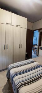 een slaapkamer met een bed en witte kasten bij Casa Maria do Mar in Florianópolis