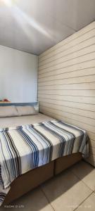 een bed in een kamer met een muur bij Casa Maria do Mar in Florianópolis