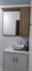 een badkamer met een wastafel en een spiegel bij Casa Maria do Mar in Florianópolis