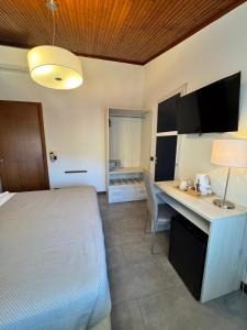a bedroom with a bed and a desk with a lamp at Hotel Venezia in La Spezia