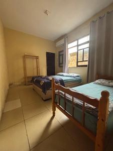 Un dormitorio con dos camas y una ventana. en Casa na Barra de São Miguel Barra Mar, en Barra de São Miguel