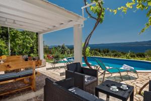 a patio with a table and chairs and a swimming pool at Holiday Home Vineyard House in Bol