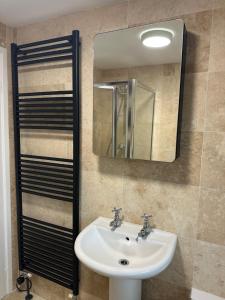 Un baño con lavabo, espejo y toallas. en The Garden Flat, en Dorchester