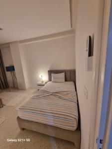 a bedroom with a bed with a striped bedspread at chez-moi sfax in Sfax +3 photos