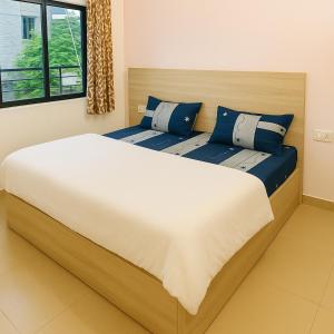 two beds with blue pillows in a bedroom at Radha Rachna Apartment in Vrindāvan