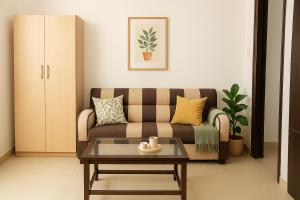 a living room with a couch and a coffee table at Radha Rachna Apartment in Vrindāvan +18 photos