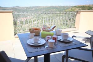 a blue table with plates and cups on a balcony at Le Terrazze della Planargia B&B in Magomadas