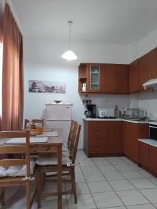 a kitchen with wooden cabinets and a table and chairs at Angelo's Apt in Mesochórion