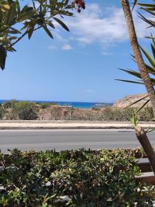 an empty road with the ocean in the background at Angelo's Apt in Mesochórion