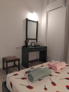 a bedroom with a bed with a mirror and a table at Angelo's Apt in Mesochórion
