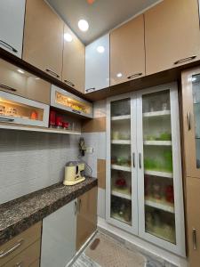 a kitchen with white cabinets with glass doors at DeeHa Niwas - A Banarasi Home in Varanasi