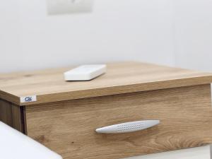 un telecomando bianco appoggiato su un tavolo di legno di Ledio GuestHouse a Përmet