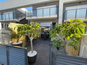 een balkon van een gebouw met bomen in potten bij Casa Familiar in Puerto Marino