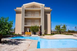 a building with a swimming pool in front of it at Bed&BikeRome GALERIA ANTICA in Santa Maria di Galeria