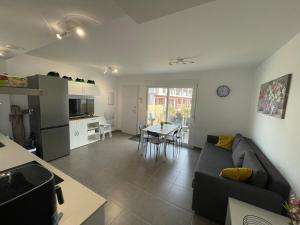 een woonkamer en keuken met een bank en een tafel bij Casa Familiar in Puerto Marino