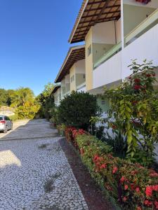 a cobblestone street next to a building with flowers at Cond Moradas de Guarajuba in Guarajuba
