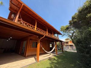 a wooden house with a rope hanging from it at Casa espaçosa na Guarda do Embaú in Palhoça