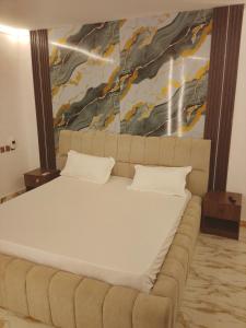 a large bed in a room with a painting on the wall at Imaginus resort in Ijebu Ode +2 photos