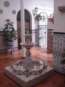 a fountain in the middle of a building at Hostal Toscano in San Juan del Puerto