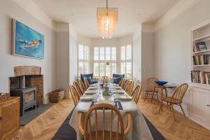 a dining room with a long table and chairs at Holmwood by Keepers Cottages in Walmer