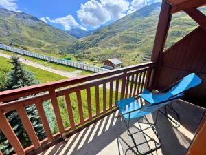 a blue chair on a balcony with a view of mountains at Résidence Valmont - Appartement 4 personnes aux Ménuires MAE-5664 in Les Menuires +5 photos