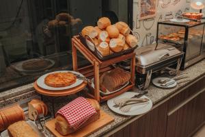 a bunch of bread and pastries on a counter at Hotel BR 364 in Cacoal