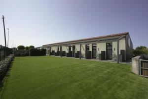 a building with a large lawn in front of it at Langre Homely Rooms in Galizano