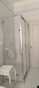 a white bathroom with a shower and a white chair at HOME SWEET HOME Casa vacanze e affitti brevi in Trani