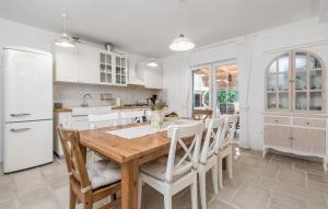 a kitchen with a wooden table and white appliances at VILLA MATIJA in Cesarica