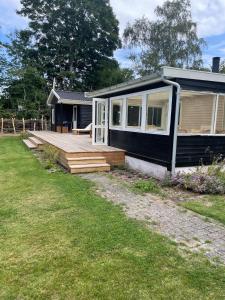 a small house with a porch and a deck at Modern and cozy holiday home in Jægerspris