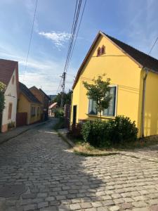 a cobblestone street in front of a yellow house at Szent Flórián Tűzoltó Panzió Visegrád in Visegrád