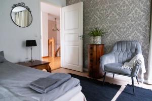 una camera da letto con un letto, una sedia e uno specchio di Villa Iris, Nagu a Finby