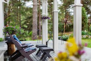 un portico con due sedie e un tavolo con fiori di Villa Iris, Nagu a Finby