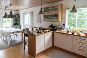 una cucina con armadi bianchi e tavolo da pranzo di Villa Iris, Nagu a Finby