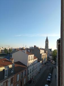 a view of a city street with buildings and a church at flowers room au coeur de saint Ouen parking gratuit in Saint-Ouen