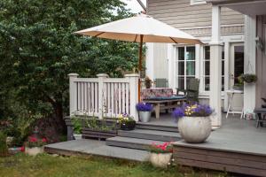 un portico con un ombrellone, un tavolo e una panca di Villa Iris, Nagu a Finby