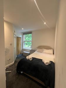 a bedroom with a bed with a black blanket at Cozy hotel-style city apartment in Amley