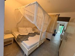 a white bed with a canopy in a room at La Casa Di Nico Studio Lillies Hse 5 in Mombasa